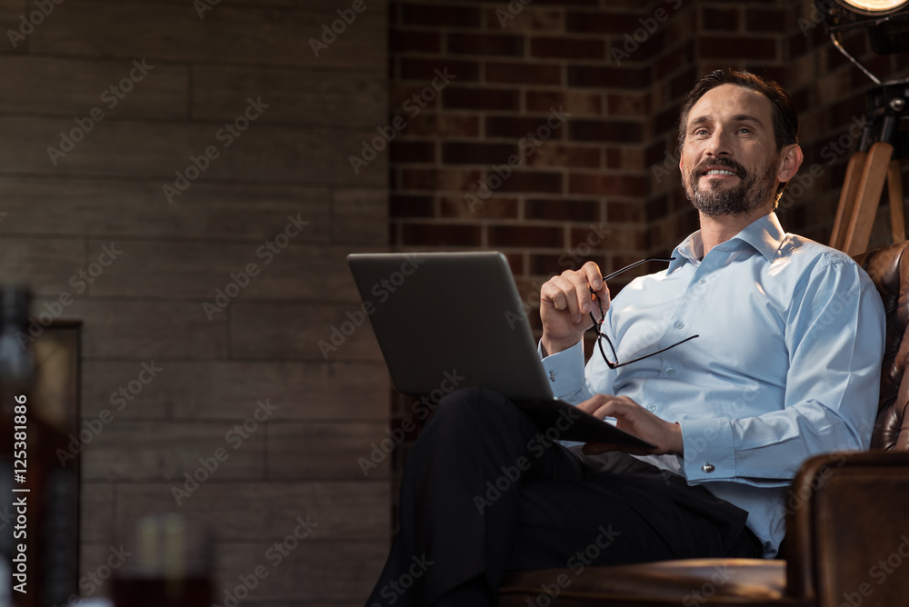 Cheerful self employed man holding his glasses Cheerful self employed man holding his glasses