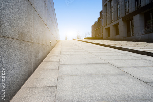 empty footpath between modern building with sunbeam