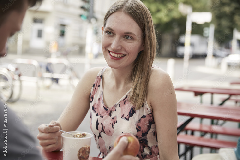 Smiling woman looking at man at a sidewalk cafe Smiling woman looking at man at a sidewalk cafe