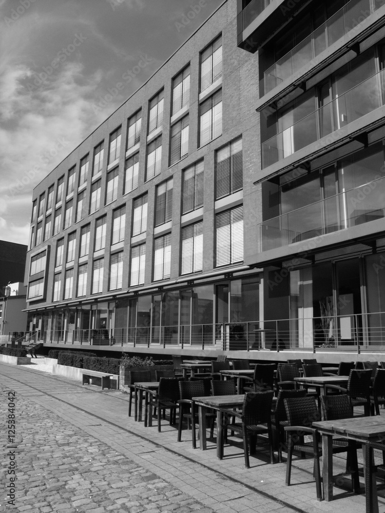 Hafenpromenade mit Kopfsteinpflaster vor modernen Bürogebäuden und Gastronomie am Kreativkai