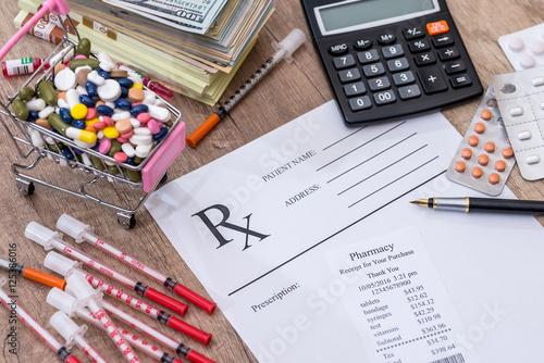 pills, money, syringe, insulin. rx on desk