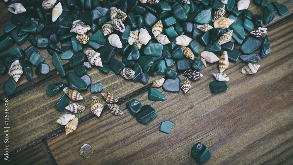 Malachite on wooden background, small shells on a wooden backgro Malachite on wooden background, small shells on a wooden backgro