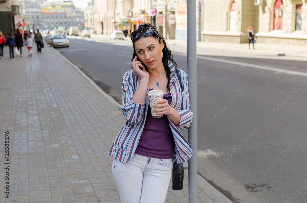 Fototapeta premium girl walking on the city with her phone