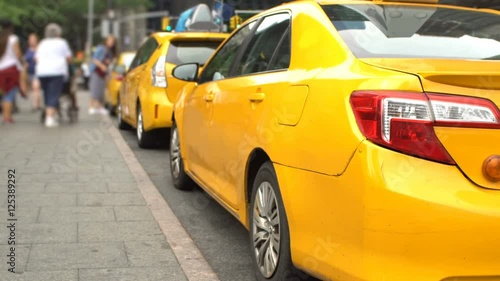 Yellow taxi vehicles waiting for passengers in New York City, wide angle with noticeable DOF effect, no recognizable people or logos.
