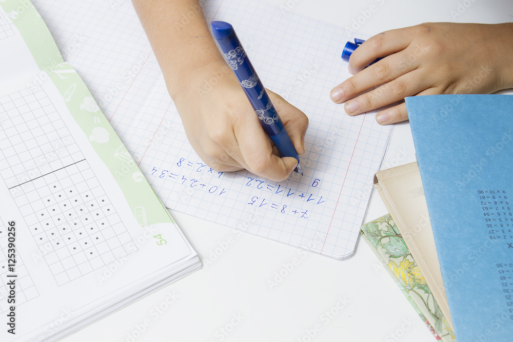 Hands of child writing on notebook. School education concept Hands of child writing on notebook. School education concept