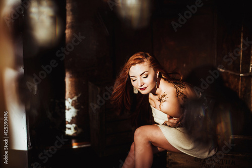 beautiful girl with red hair posing in Studio