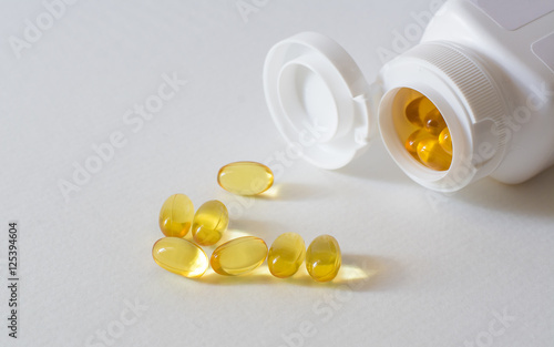 Fish oil capsules gold put on a white background