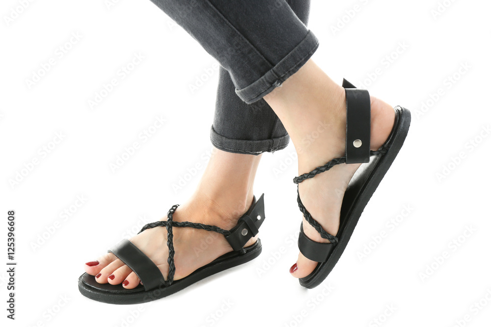 Black leather sandals on woman's feet isolated on white Black leather sandals on woman's feet isolated on white