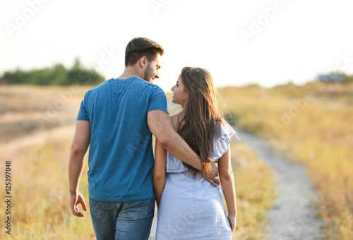 Young couple in love hugging on sunset