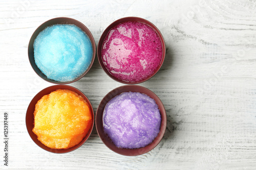 Body scrubs on wooden background