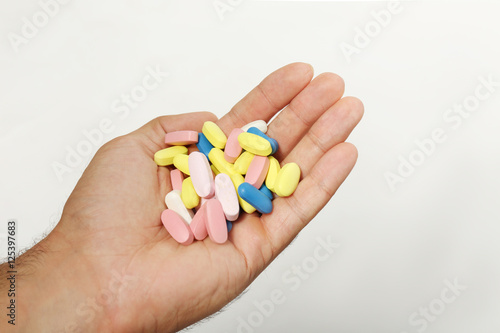Male hand holding drugs on color background