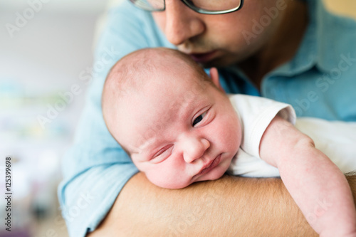 Close up, unrecognizable father holding his newborn baby son