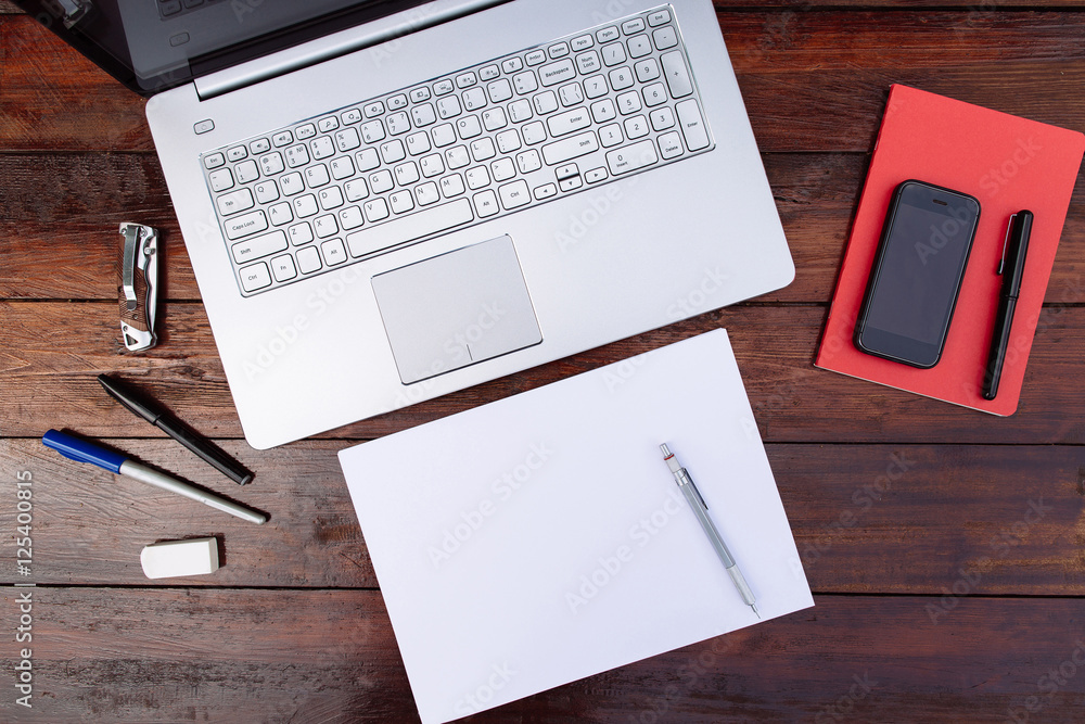 Workplace , blank sheet of paper with a pen and .mobile phone and laptop on a wooden background - Mock up Workplace , blank sheet of paper with a pen and .mobile phone and laptop on a wooden background - Mock up