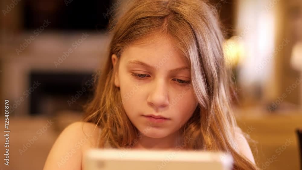 Close up of a young teen using a tablet indoors Close up of a young teen using a tablet indoors