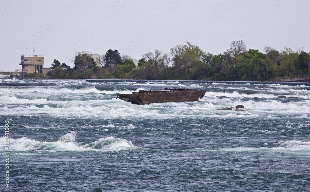Beautiful image with a broken boat on the river right before the amazing Niagara falls Beautiful image with a broken boat on the river right before the amazing Niagara falls