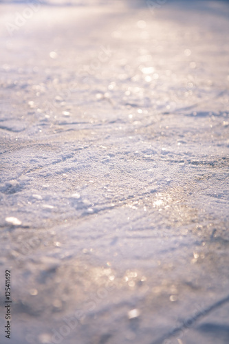 Winter background with shining snow and snowflakes on ice as Christmas background