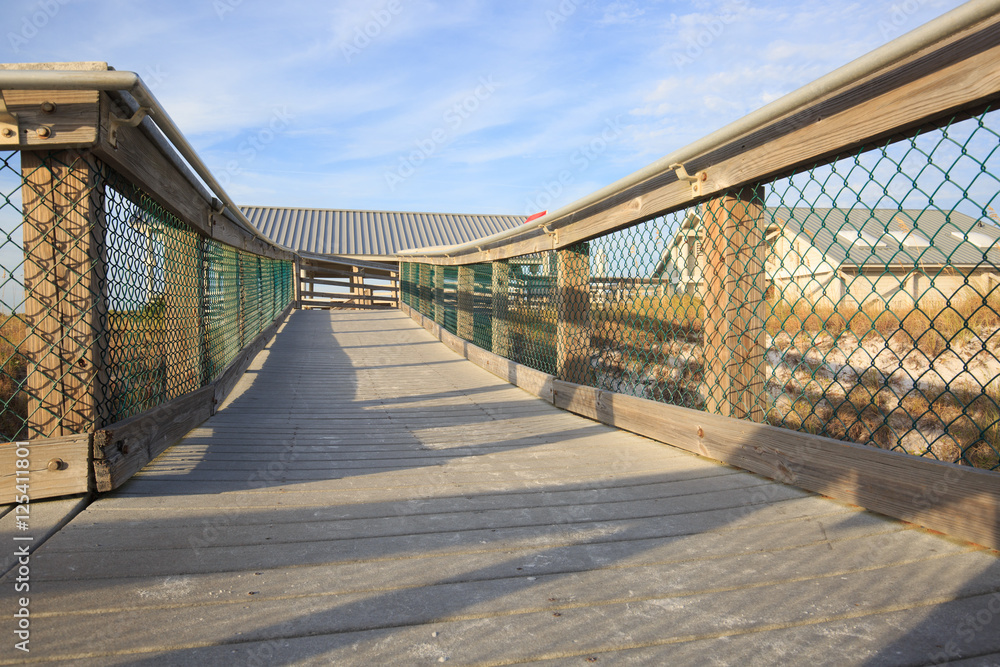 Fototapeta premium Stairs To The Beach. Wooden stairway leads to the wide sandy bea
