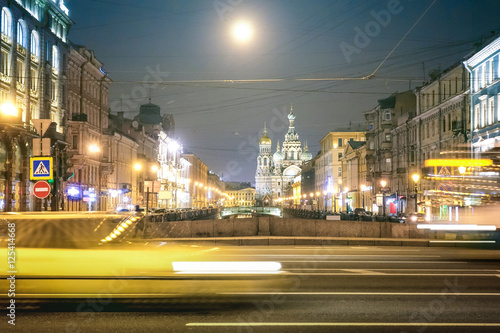 Speeding car on the street with front view of Canal Griboedova with church 