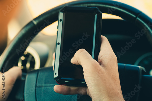 man hand with smartphone in car