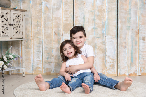 Brother and sister embracing together on the floor