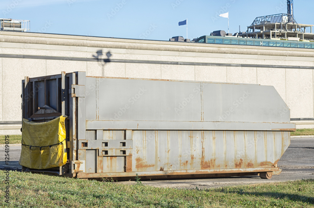 Grey waste construction container in a private parking lot Grey waste construction container in a private parking lot