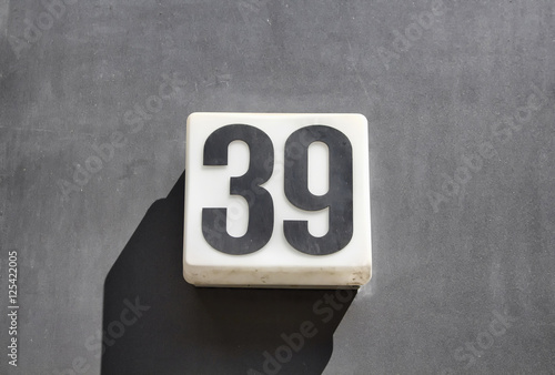 Fotografie Modern, simple, monochromatic building number on concrete surface in Berlin