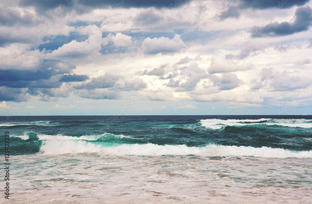 Retro toned dramatic stormy beach scene. Grey clouds and rough seas on a deserted Garie beach, Royal National Park, New South Wales, Australia Retro toned dramatic stormy beach scene. Grey clouds and rough seas on a deserted Garie beach, Royal National Park, New South Wales, Australia