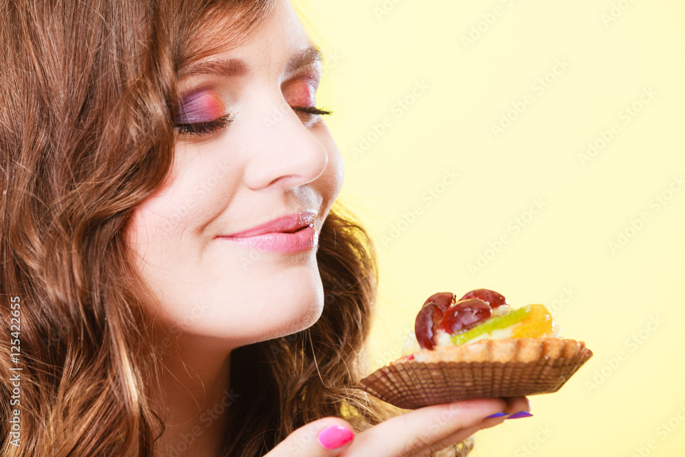 woman closed eyes holds cake in hand