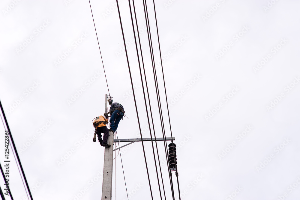 Electrician lineman repairman worker at climbing work on electric post power pole Electrician lineman repairman worker at climbing work on electric post power pole