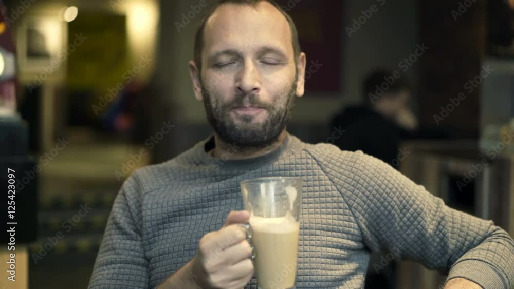 Young man relaxing and drinking coffee in cafe
Young man relaxing and drinking coffee in cafe