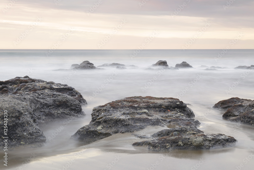 Serene seascape in Azkorri beach, Biscay, Basque Country, Spain. Long exposure on a cloudy day.