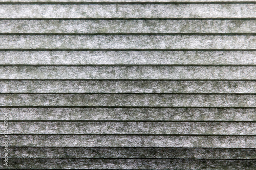 Gray / green window covering close up with horizontal parallel lines