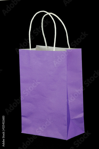 purple paper gift bag isolated on black background