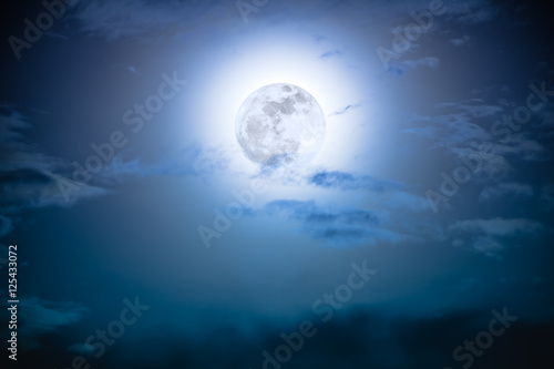 Nighttime sky with clouds and bright full moon with shiny.