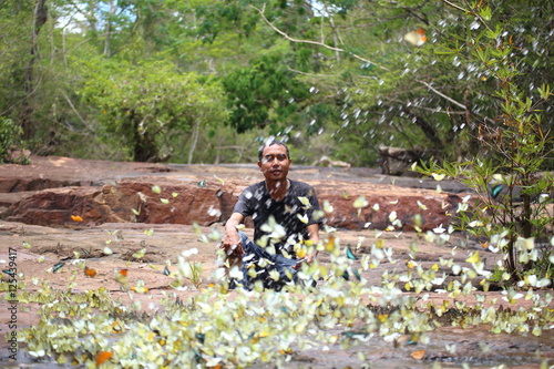 Quadro em tela Man sitting in the middle of Swarms of butterflies ,Pang Sida National Park at T