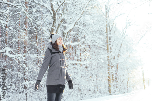 Happy girl walking in a beautiful winter forest