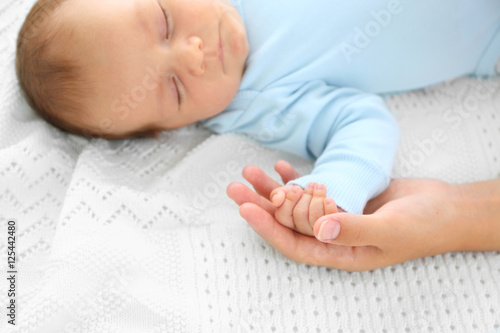 Mother holding hand of cute...
