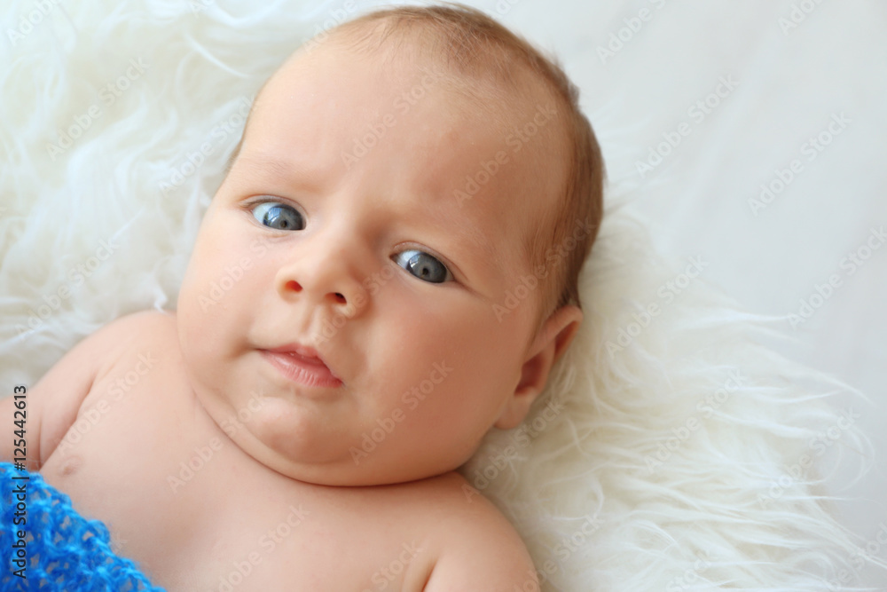 Portrait of cute baby lying on fluffy plaid, close up view Portrait of cute baby lying on fluffy plaid, close up view