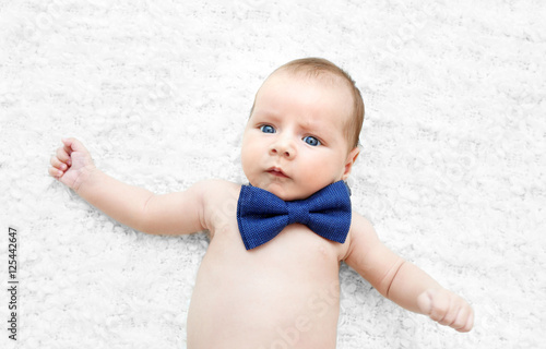 Cute baby with bow tie lyin...