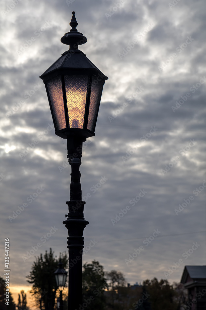 Street light at sunrise. Classic street lantern in modern city.