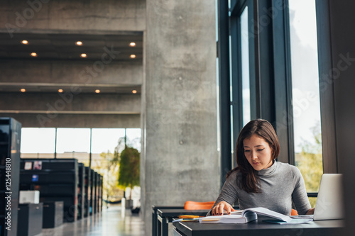 Female student doing assignments in library