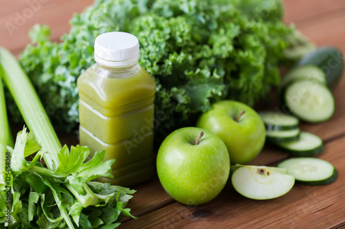 close up of bottle with green juice and vegetables