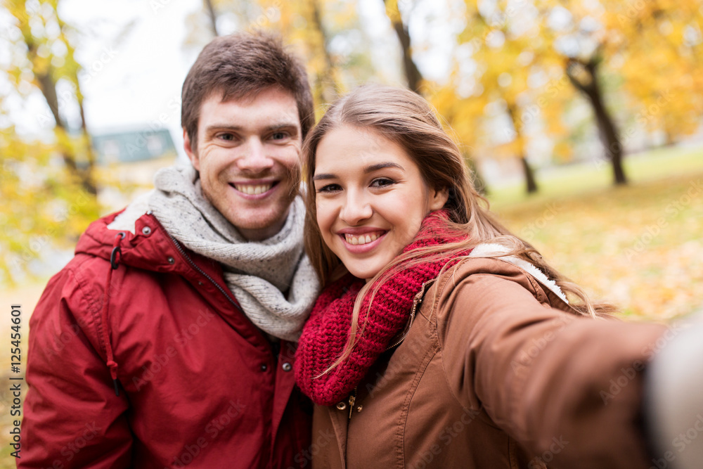 happy young couple taking selfie in autumn park happy young couple taking selfie in autumn park
