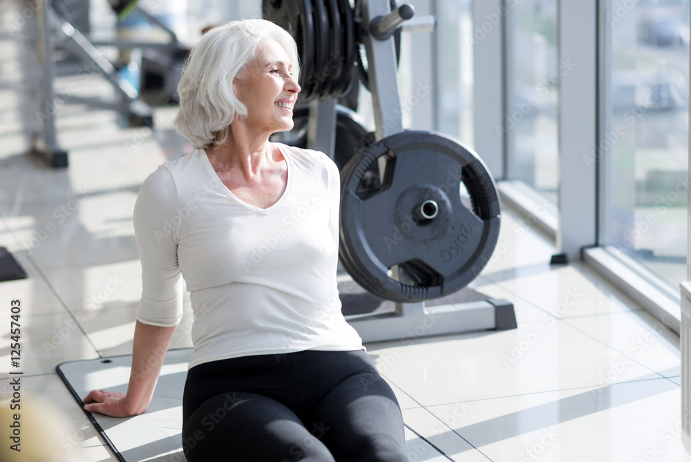 Delighted joyful senior woman relaxing in the gym. Delighted joyful senior woman relaxing in the gym.