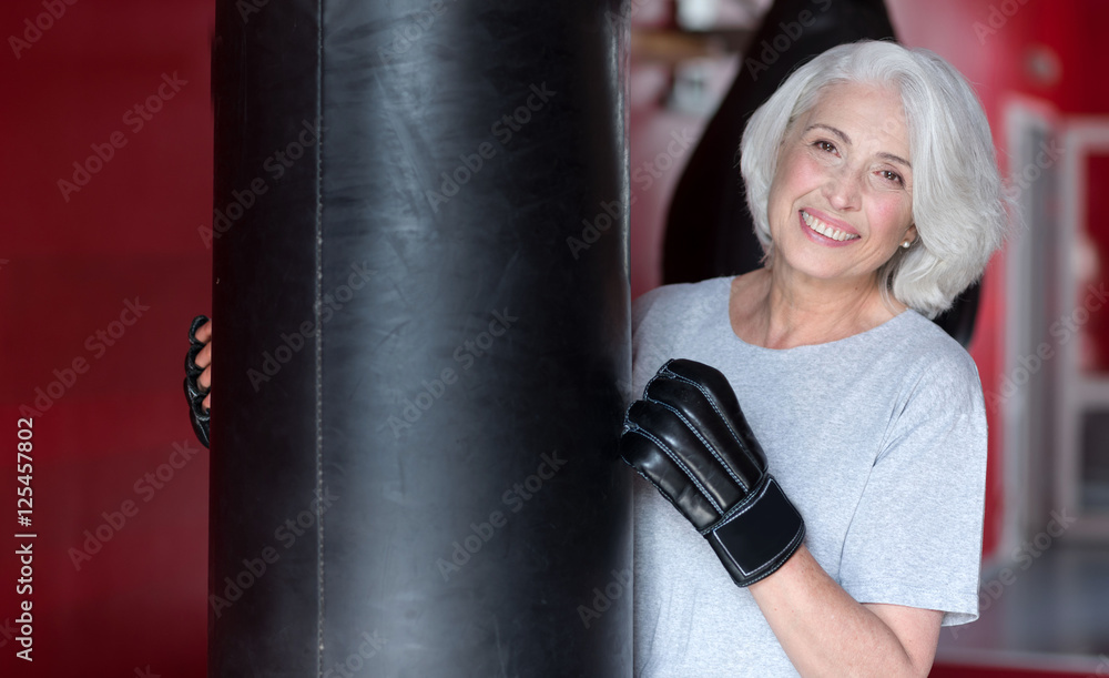 Joyful smiling woman having boxing lesson.