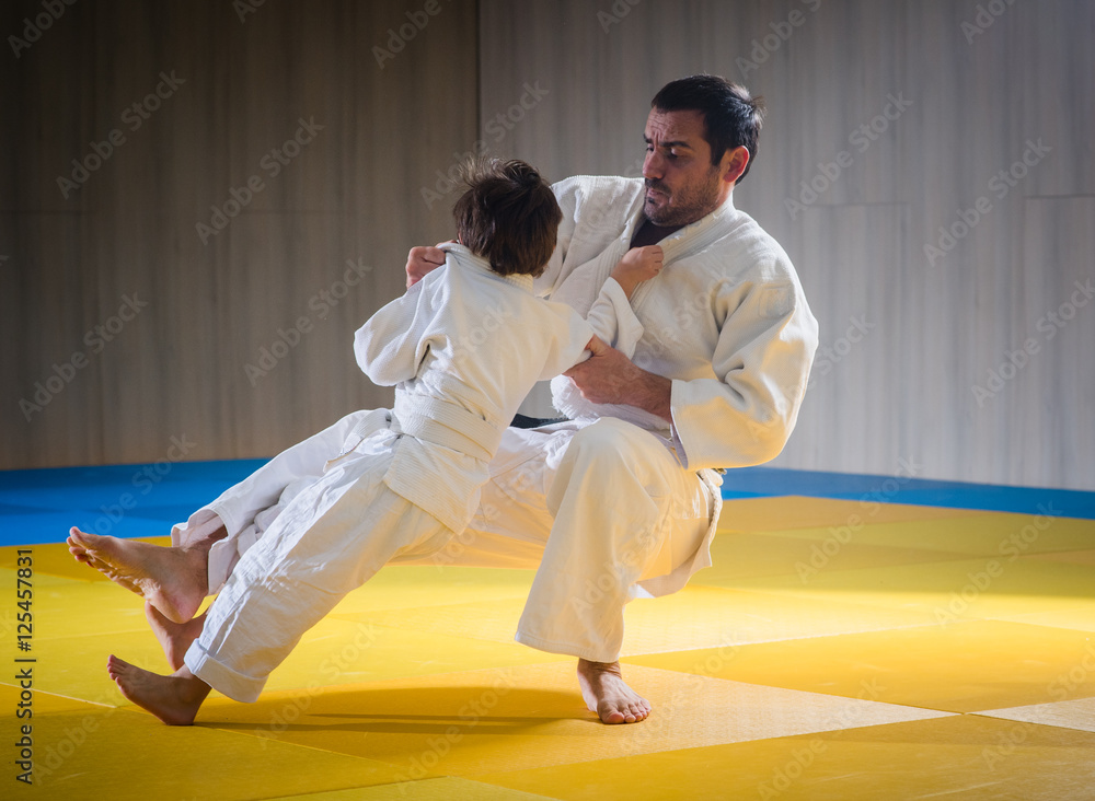 Man and young boy are training judo throw Man and young boy are training judo throw