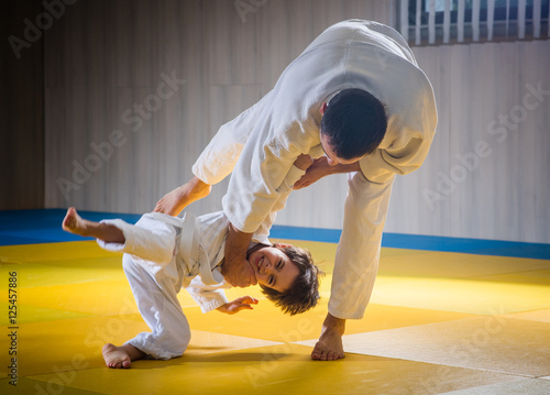 Man and young boy are training judo throw photo