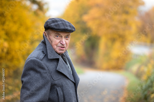 Elderly man on a walk in autumn landscape