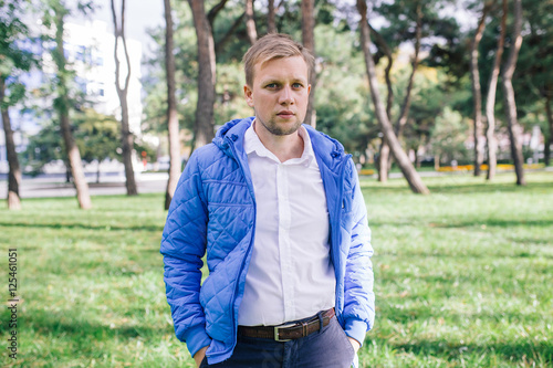 portrait of a young man in a white shirt and a blue jacket outdoor