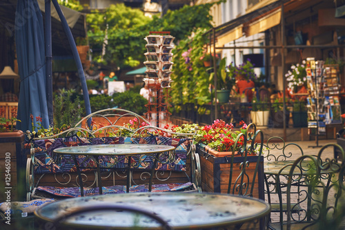 Пустой столик в кафе на красочной улице с цветами photo